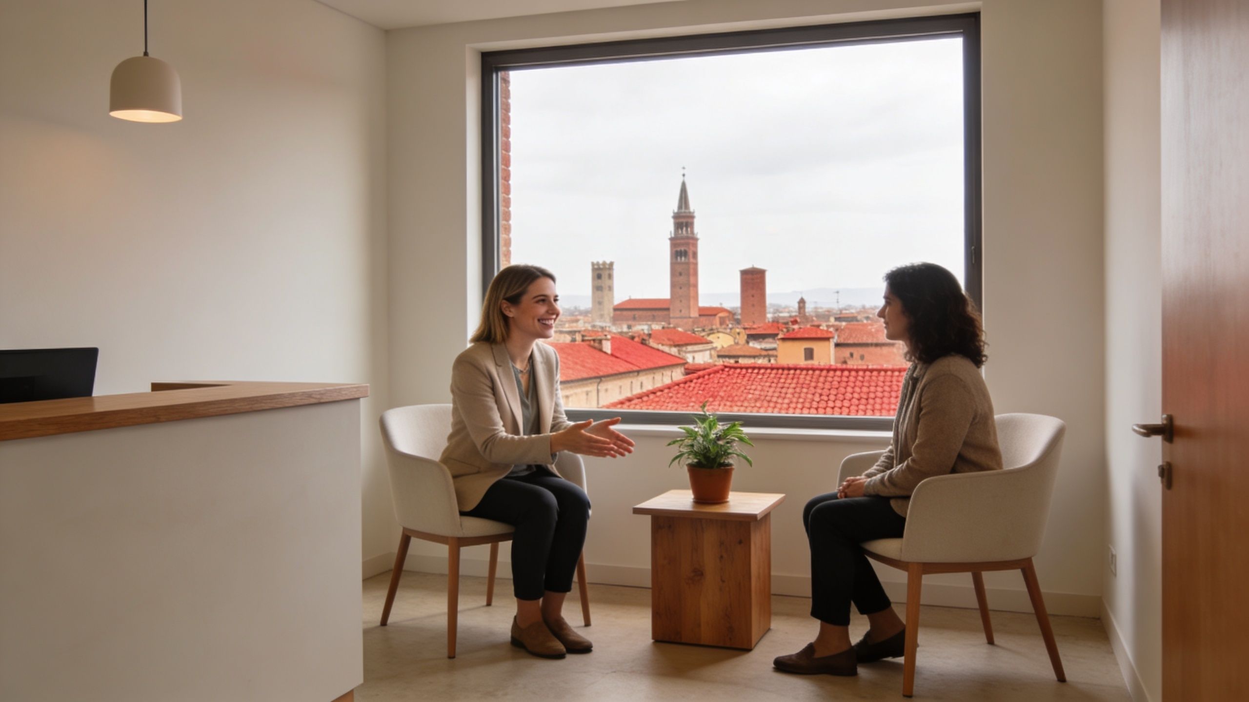 A professional counselor talking with a client in a bright office overlooking the historic city of Bologna.